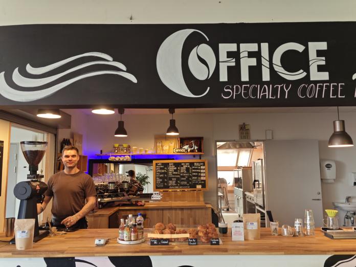 Billedet viser caféens forpagtar, Elias, bag disken.