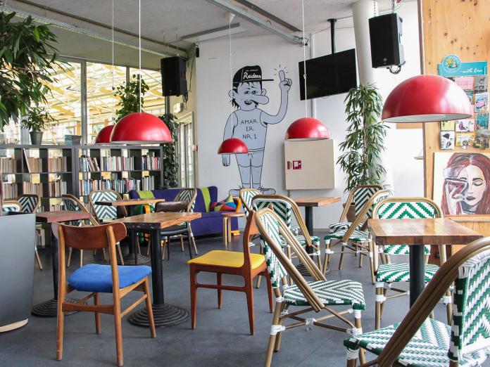 Billedet viser caféområdet med borde og stole.